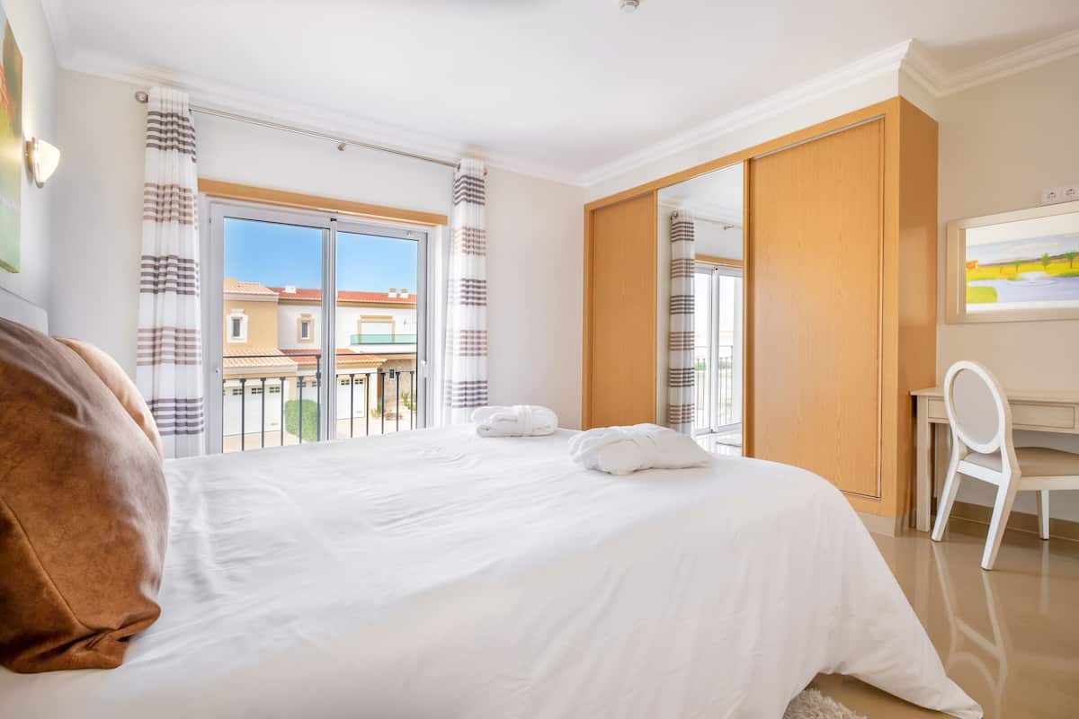 Een hotelkamer met een groot bed, een bureau en een stoel.