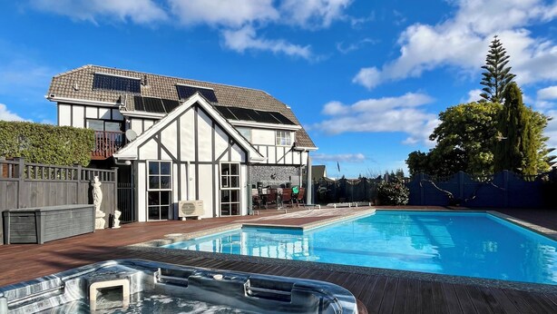 A modern house with a swimming pool, a hot tub, and a wooden deck. - Tudor Manor Bed & Breakfast (Paraparaumu)