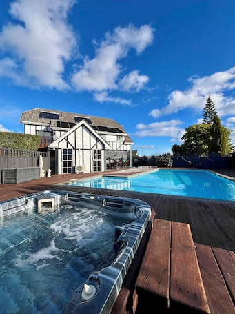 Una piscina al aire libre, sillones reclinables de piscina