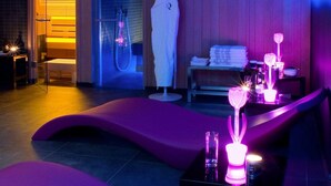 A modern spa room with a heated floor, a large white sculpture, and a massage table. - Hôtel Quatorze (Colmar)