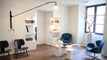 Relax in a stylish waiting area with comfortable seating and a unique light fixture.