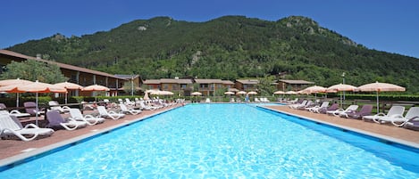 Una piscina cubierta, una piscina al aire libre de temporada, sombrillas