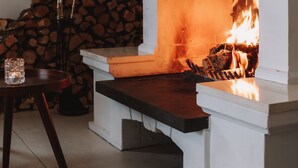 A fireplace with a white mantel and a fire burning inside. - Hótel Berg (Reykjanesbær)