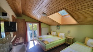 A room with two beds, a bathroom with a sink, and a skylight. - Pension Heino (Saas Grund)