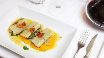 A plate of food with a fork and knife on a white tablecloth.
