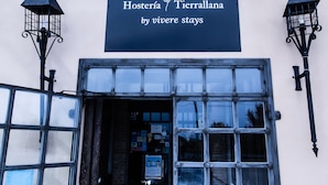 A building entrance with a sign reading "Hosteria / Terrallana by viveire stays". - Hosteria Tierrallana by Juypehotel (El Provencio)