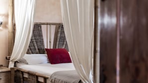 A room with a bed, a nightstand, and a wooden door. - Hosteria Tierrallana by Juypehotel (El Provencio)