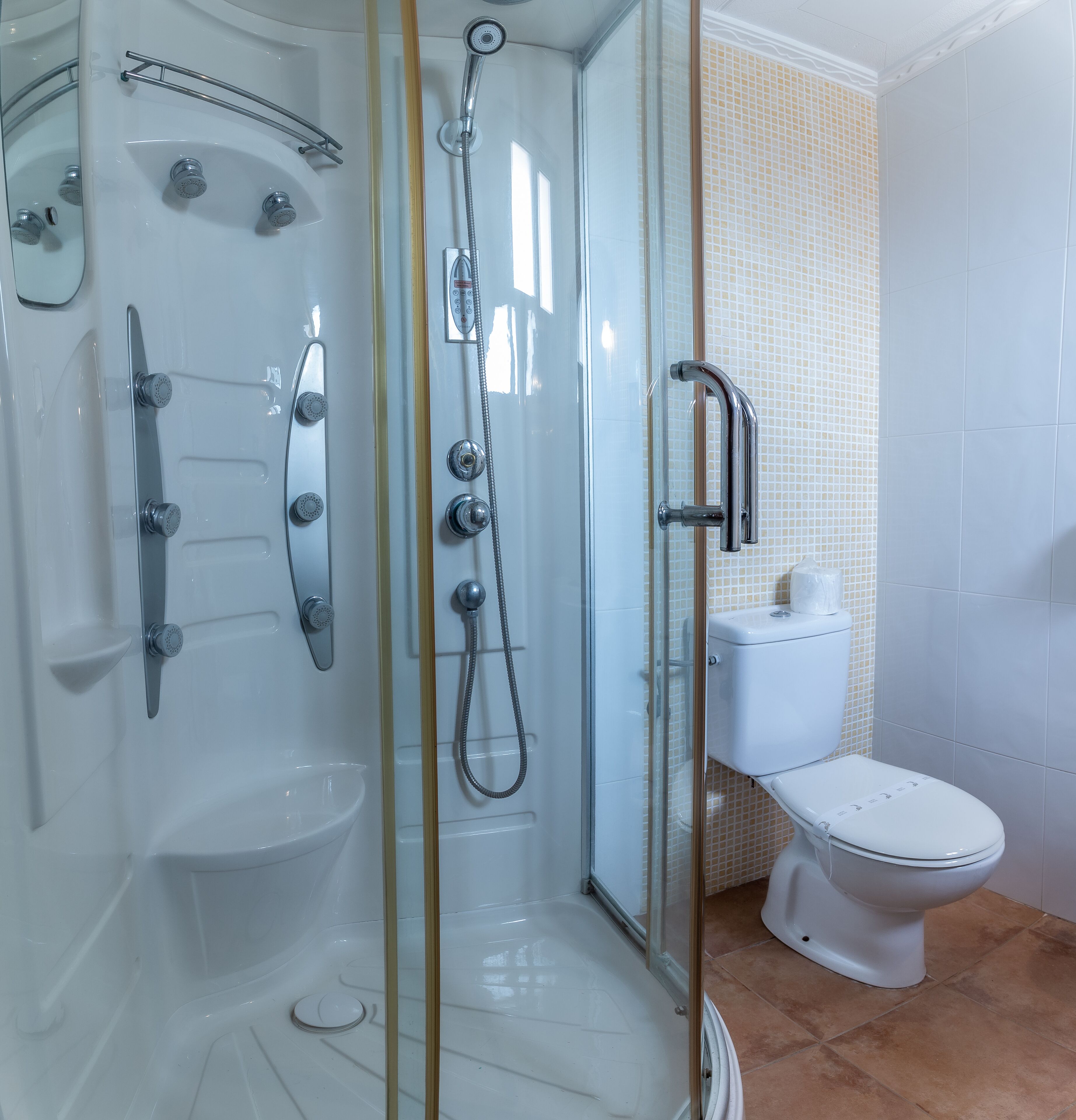 Un baño moderno con ducha de vidrio, inodoro y lavamanos.