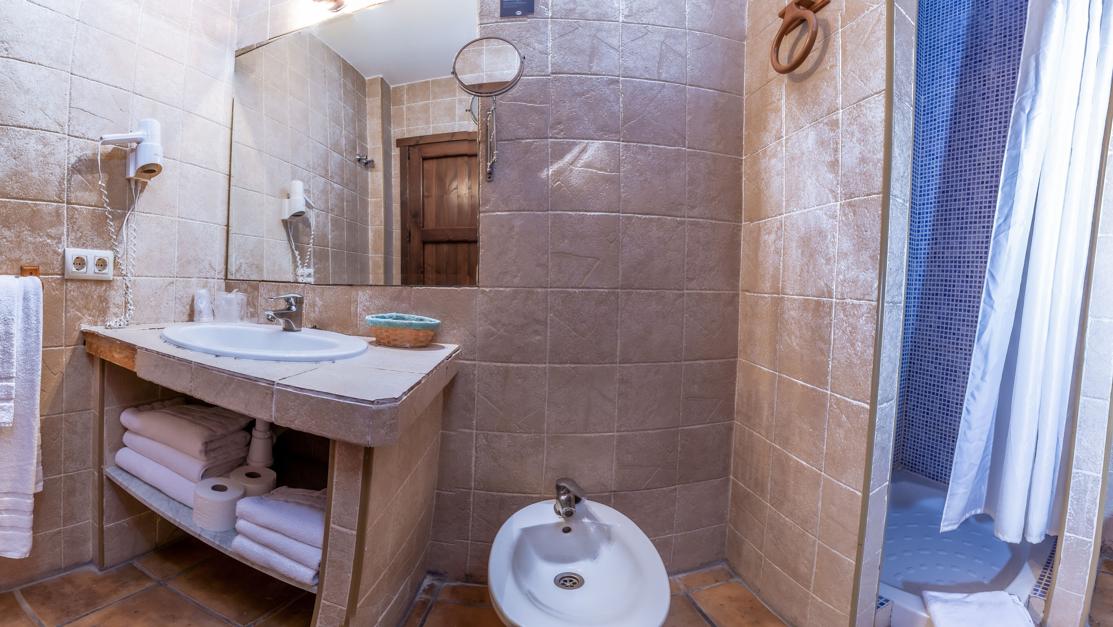 A bathroom with a sink, mirror, and urinal.