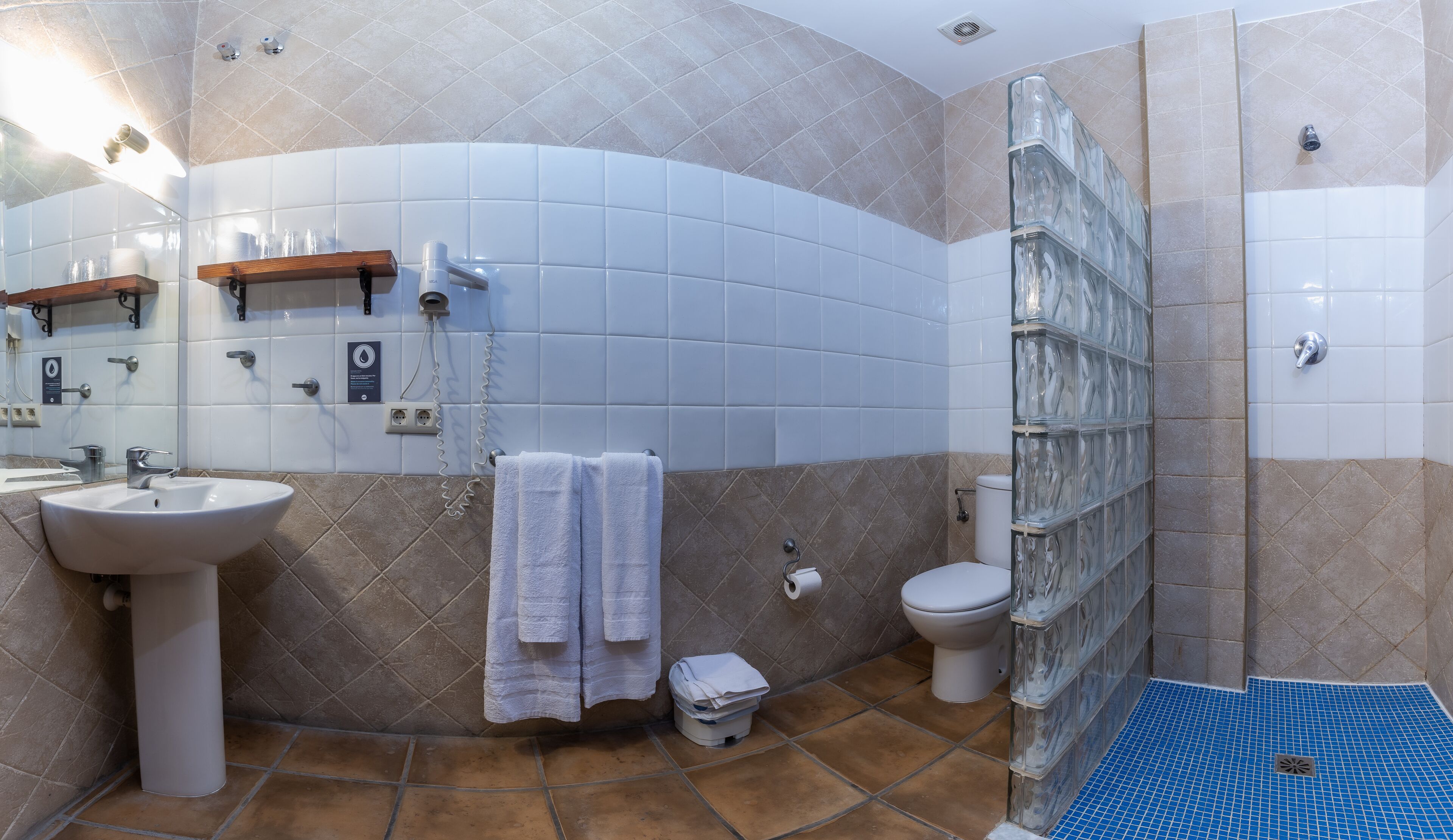 A bathroom with a sink, toilet, and shower area.