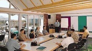 A conference room with a long table, chairs, a whiteboard, and a presentation screen. - Landhotel Combecher (Neukirchen)