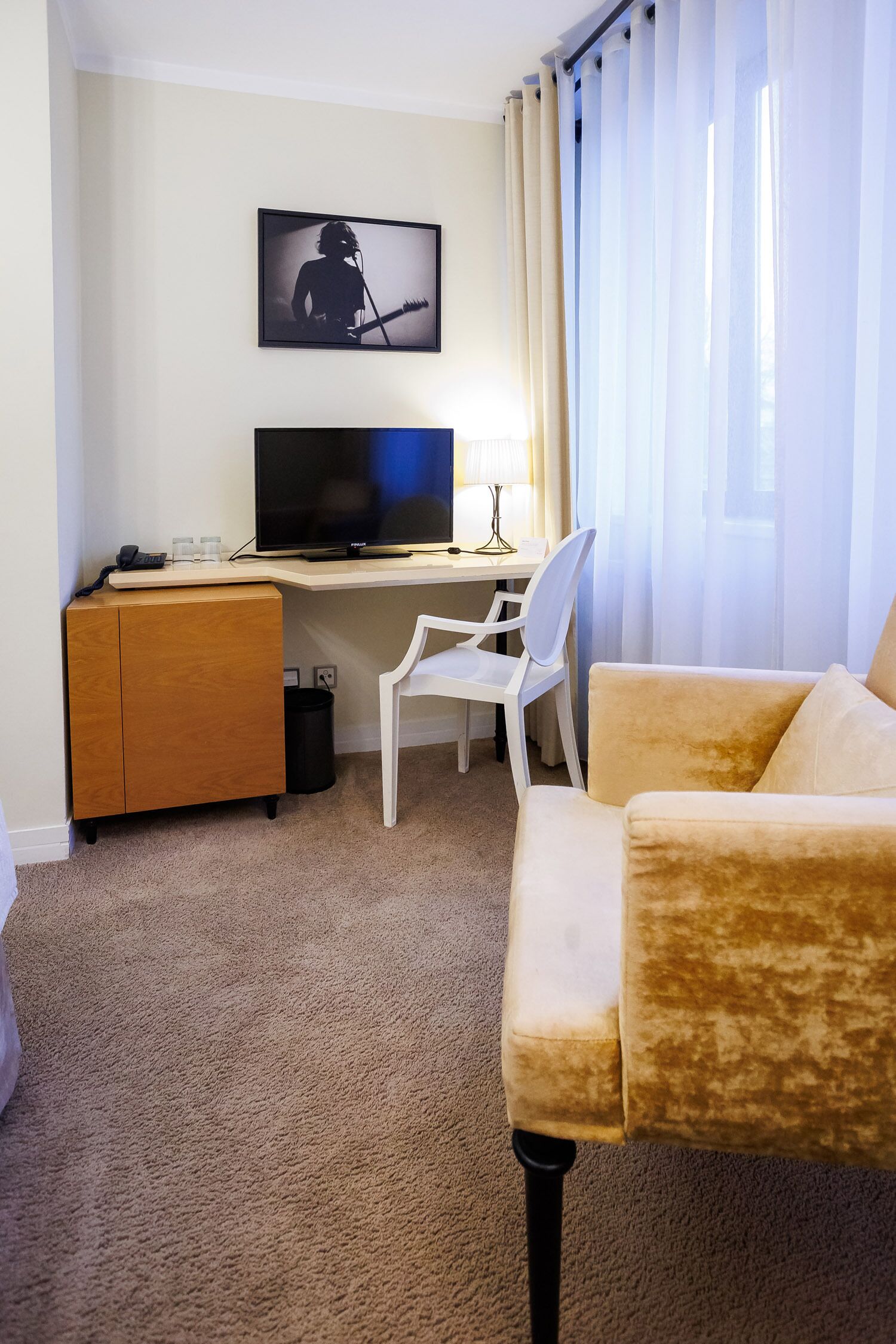 Una habitación de hotel con escritorio, televisor, sofá y una silla.