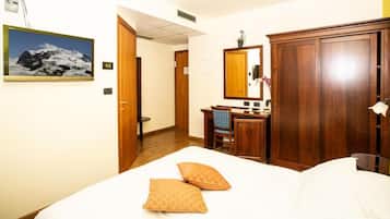 Una habitación de hotel con cama, escritorio, armario y baño.