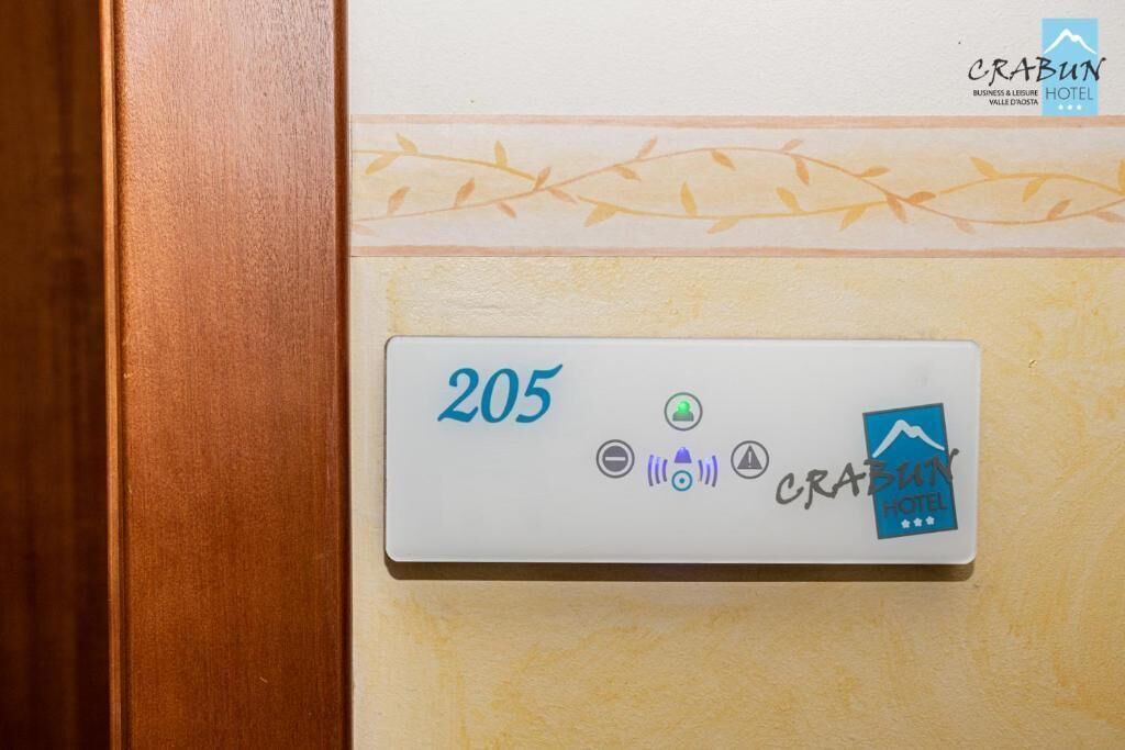 A room number plaque with the number 205, a bed icon, a Wi-Fi symbol, and the Crabun Hotel logo.