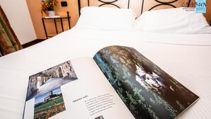 A hotel brochure open on a bed, featuring images of a castle and a forest. - Crabun (Pont-Saint-Martin)