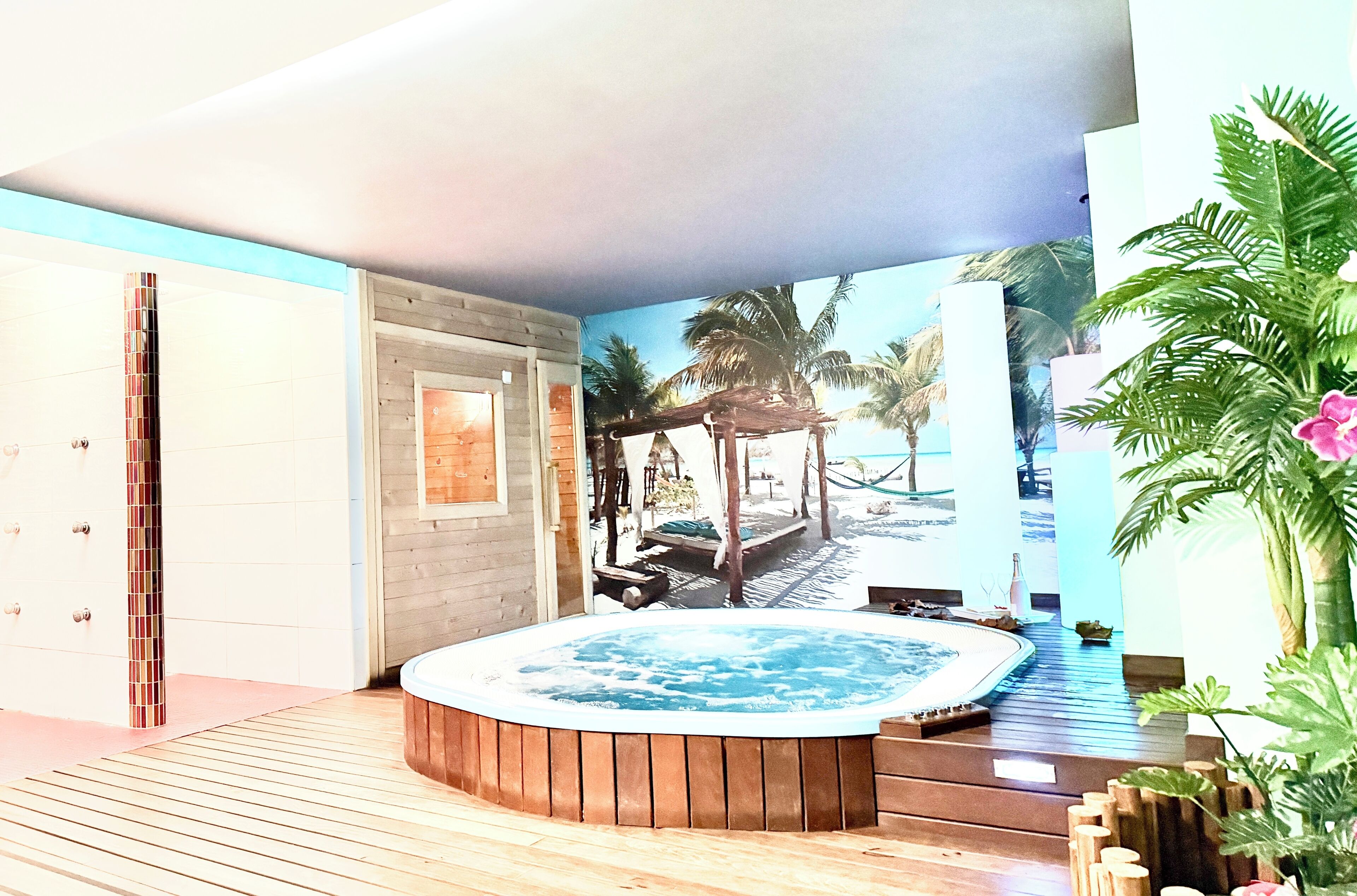 A spa area with a hot tub, wooden deck, and a mural of a tropical beach scene.