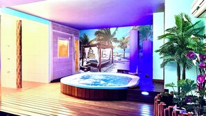 A spa area with a hot tub, wooden flooring, and a mural of a beach scene. - Hotel Galatea (Burela)