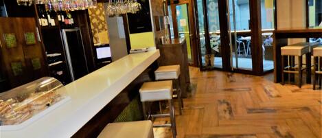 A bar area with a long counter, stools, and a glass display case.