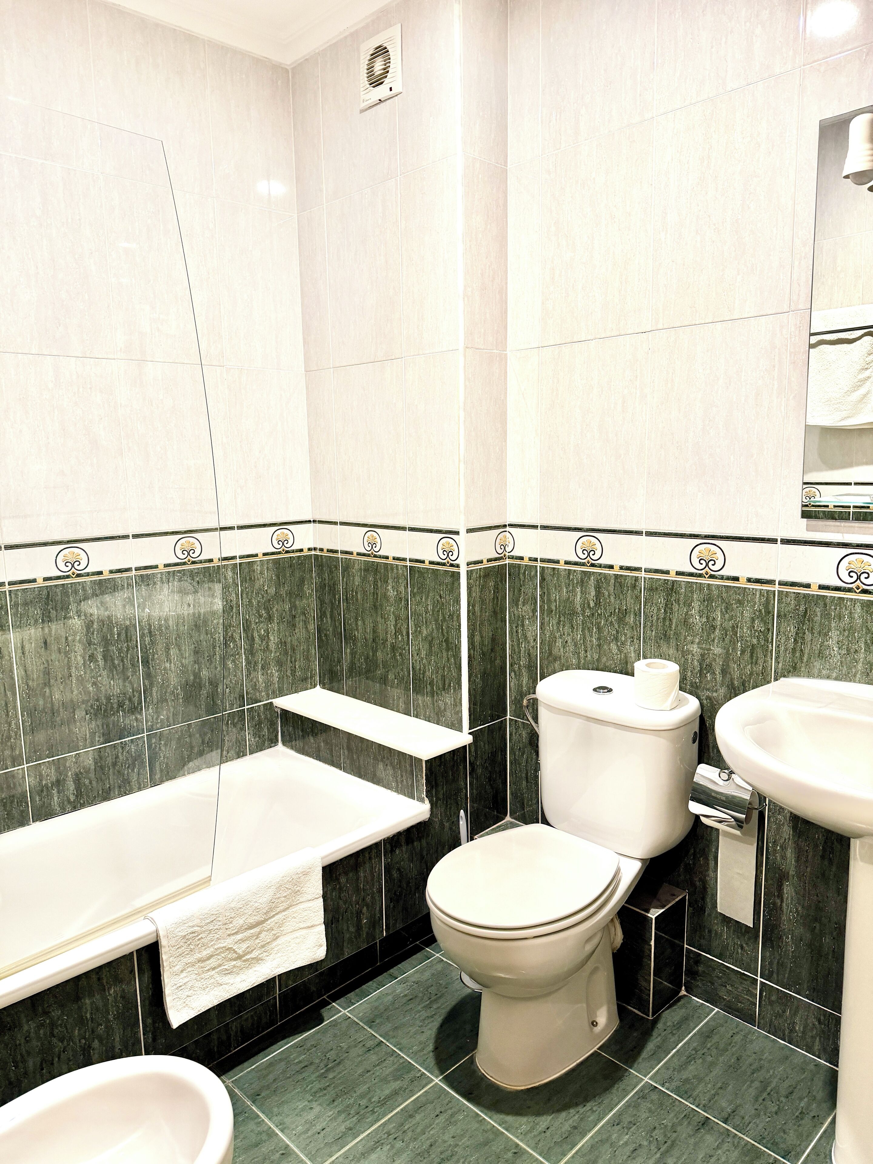 Un baño con bañera, inodoro y lavamanos.