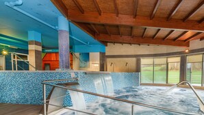 A hot tub with a tiled wall and a wooden ceiling. - Hotel Spa Norat Torre do Deza (Lalin)