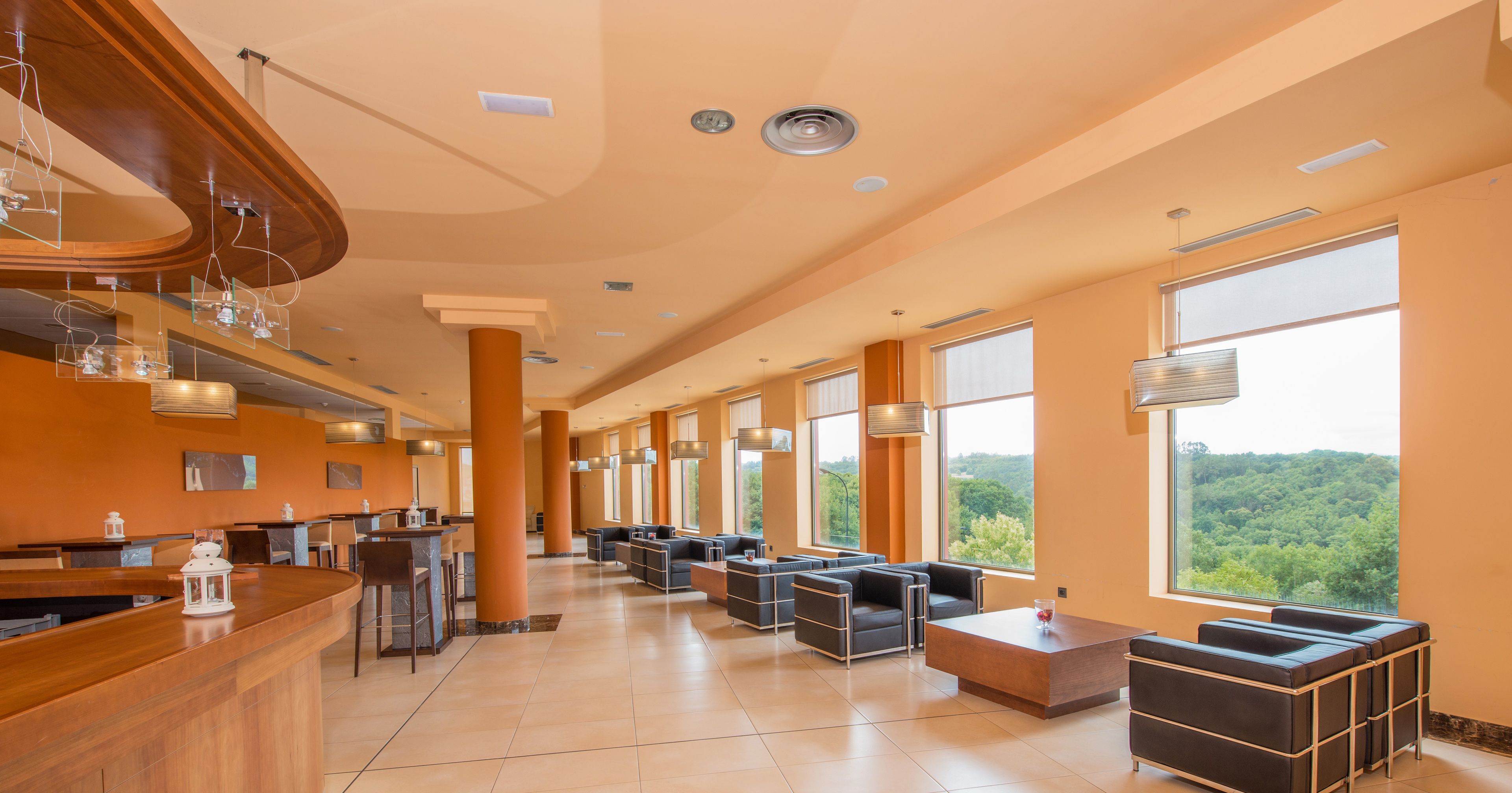 Un lobby espacioso con una recepción, zona de estar y ventanas amplias que ofrecen vistas al exterior.