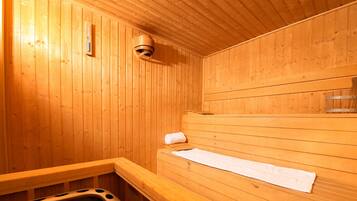 Una sauna de madera con bancos, un perchero para toallas y un respiradero.