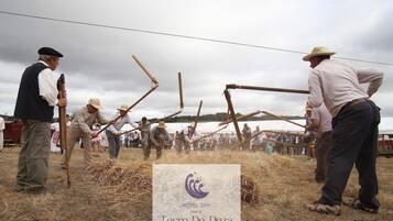Un grupo de personas participa en una actividad tradicional, con un cartel de Hotel Spa Torre Do Deza al frente.