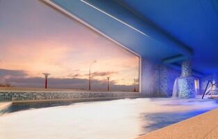 A modern spa with a large window, a tiled floor, and a blue ceiling.