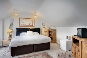 A modern bedroom with a large bed, bedside tables, a television, and a coffee machine. - St. Aiden's Guesthouse (Dublin)