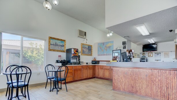 A spacious kitchen with wooden cabinets, a large island, and a dining area with chairs.