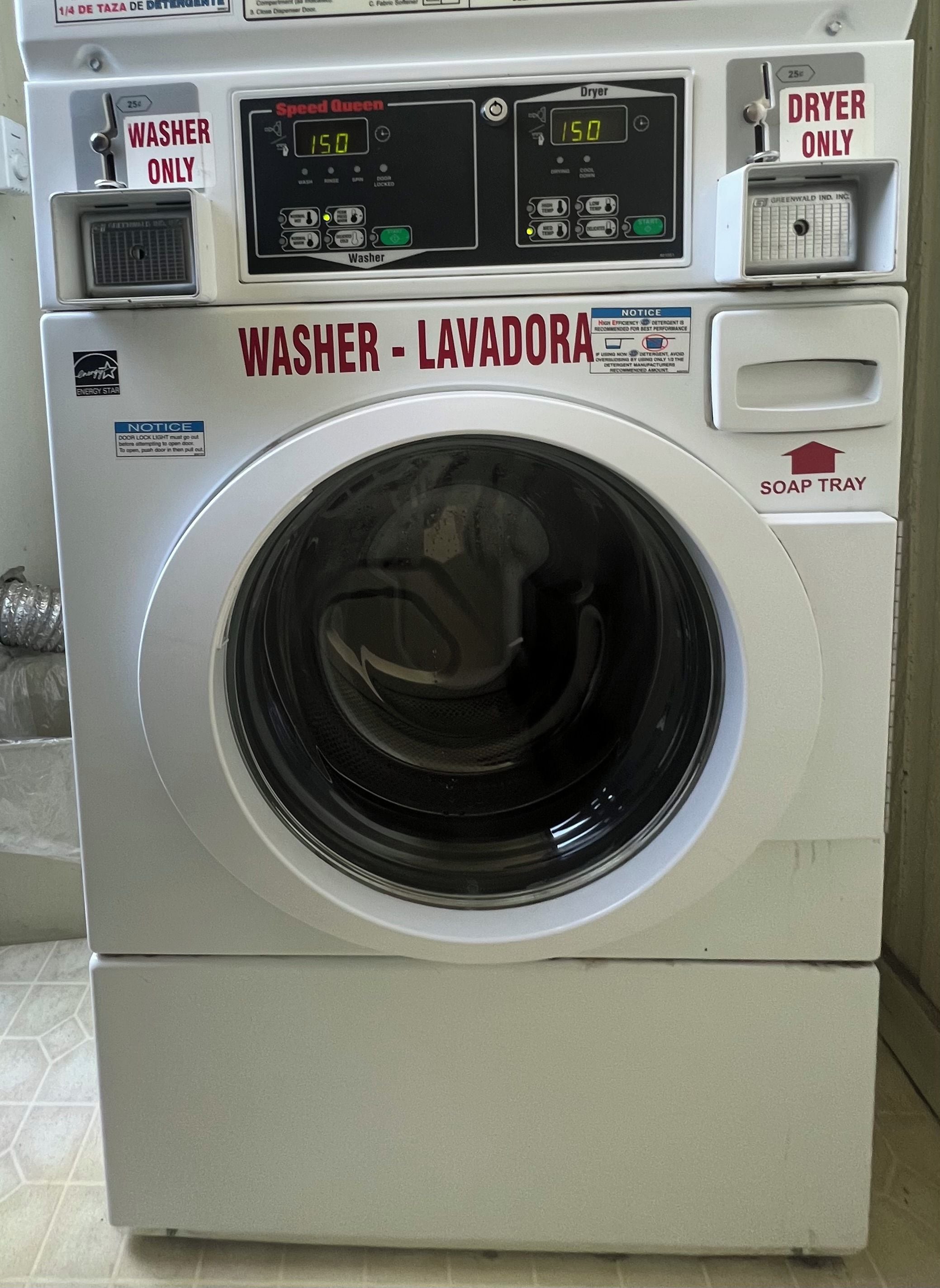 Una lavadora de carga frontal con pantalla digital, identificada como 'WASHER - LAVADORA', y un dispensador de detergente.