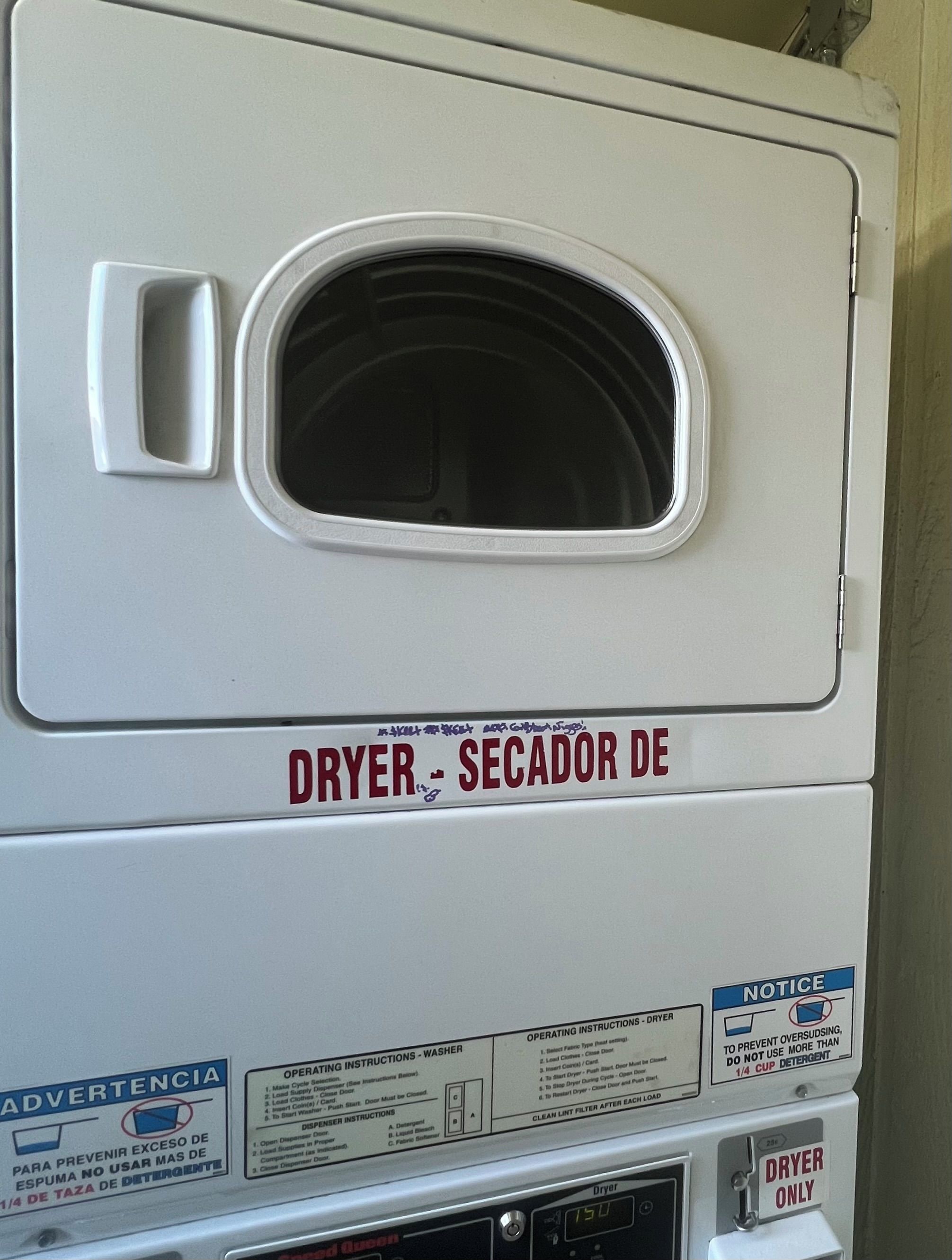 A white dryer with operating instructions and a notice about detergent usage.