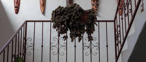 A staircase with ornate metal railings and a wall adorned with wooden masks.