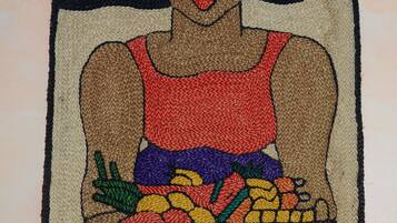 Un tapiz que muestra una figura sosteniendo verduras.