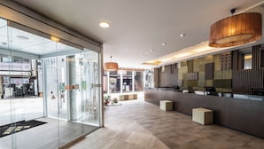 A modern hotel lobby with a reception desk, glass doors, and a tiled floor. - Hotel Vista Premio Kyoto Kawaramachi St. (Kyoto)