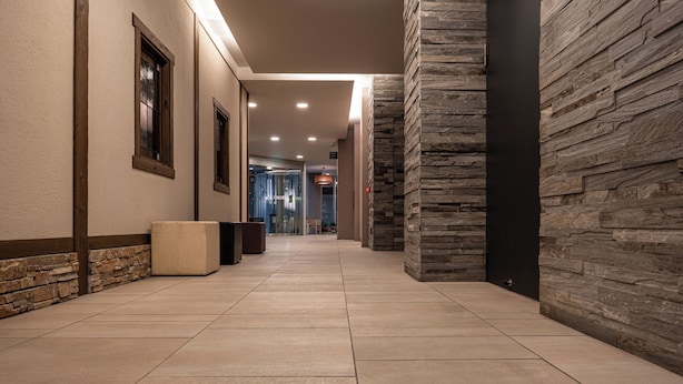 A hallway with stone walls, recessed lighting, and a tiled floor. - Hotel Vista Premio Kyoto Kawaramachi St. (Kyoto)