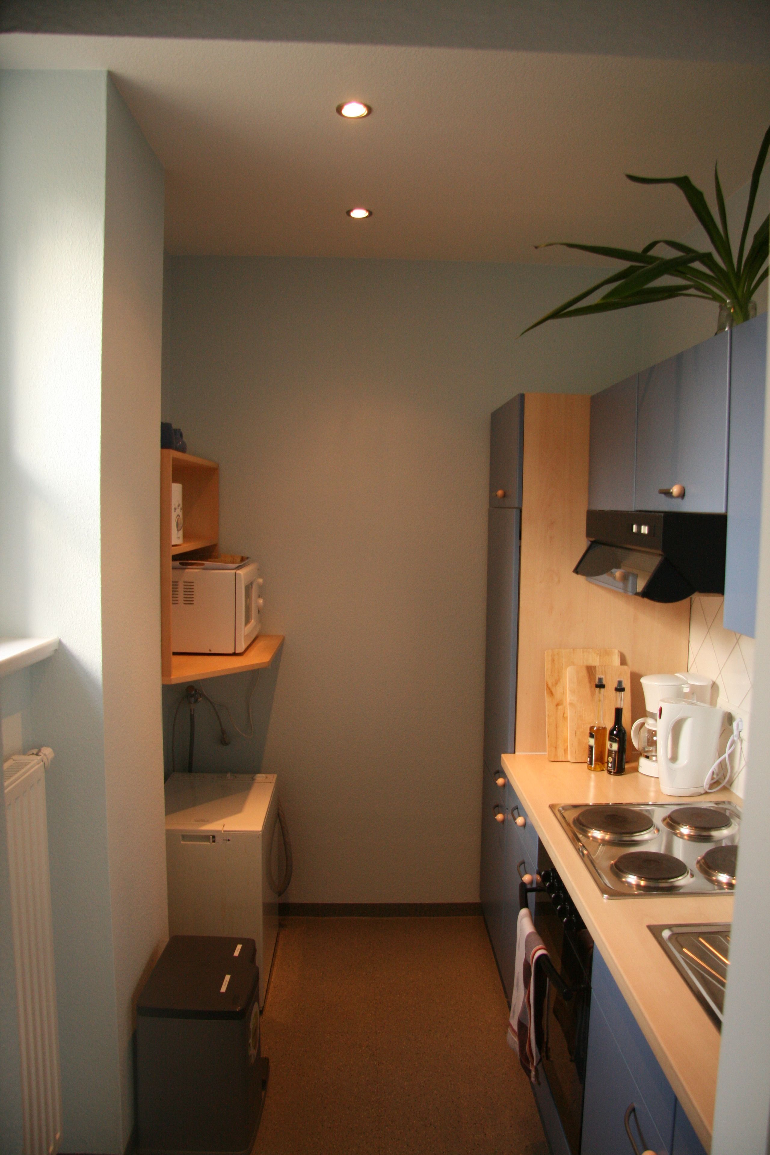 A compact kitchen with a microwave, oven, and sink.