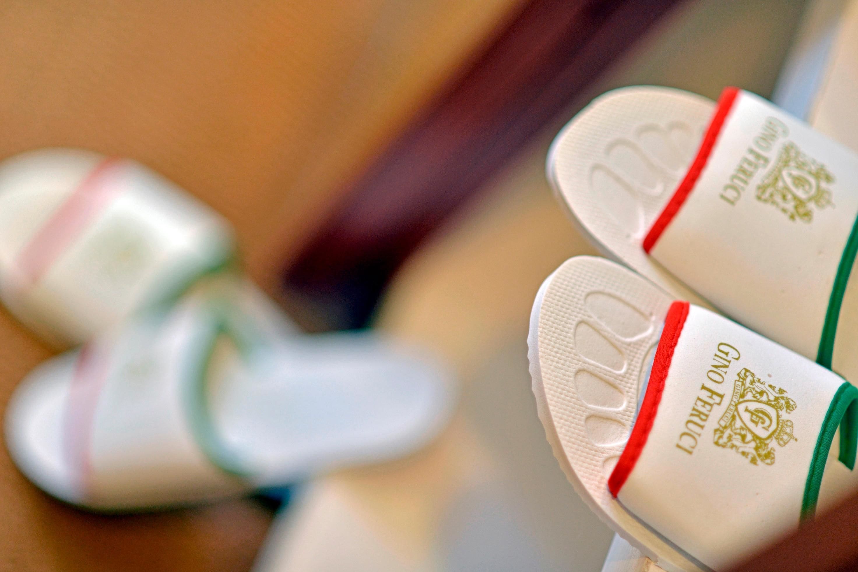 A pair of slippers with a logo and text on them.