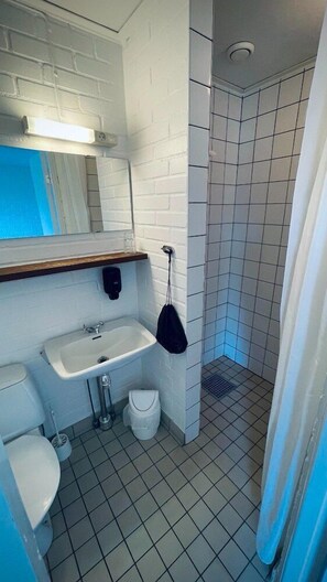A bathroom with a white sink, mirror, and toilet.