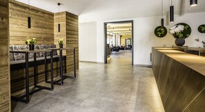 Welcome to our reception area, featuring a curved reception desk and a cozy seating area with a bench and table.