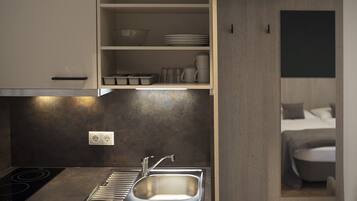 Una cocina moderna con estufa integrada, un lavabo y una encimera con armarios de almacenamiento.