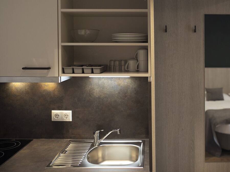 Una cocina moderna con estufa integrada, un lavabo y una encimera con armarios de almacenamiento.