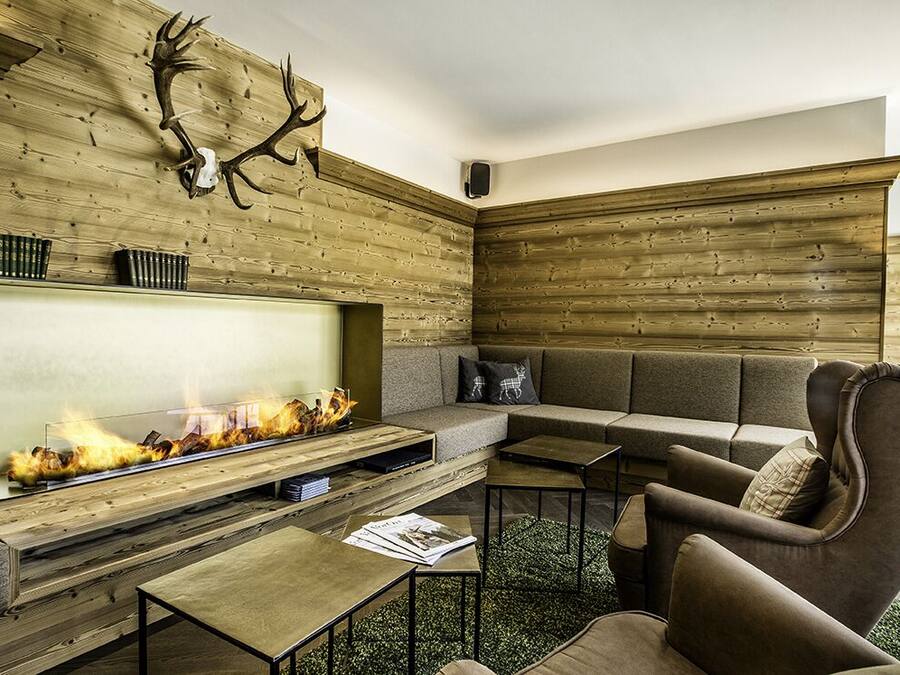 Una sala moderna con chimenea, paneles de madera, un sofá y una televisión.