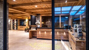 A reception area with wooden reception desk, stone walls, and a skylight.