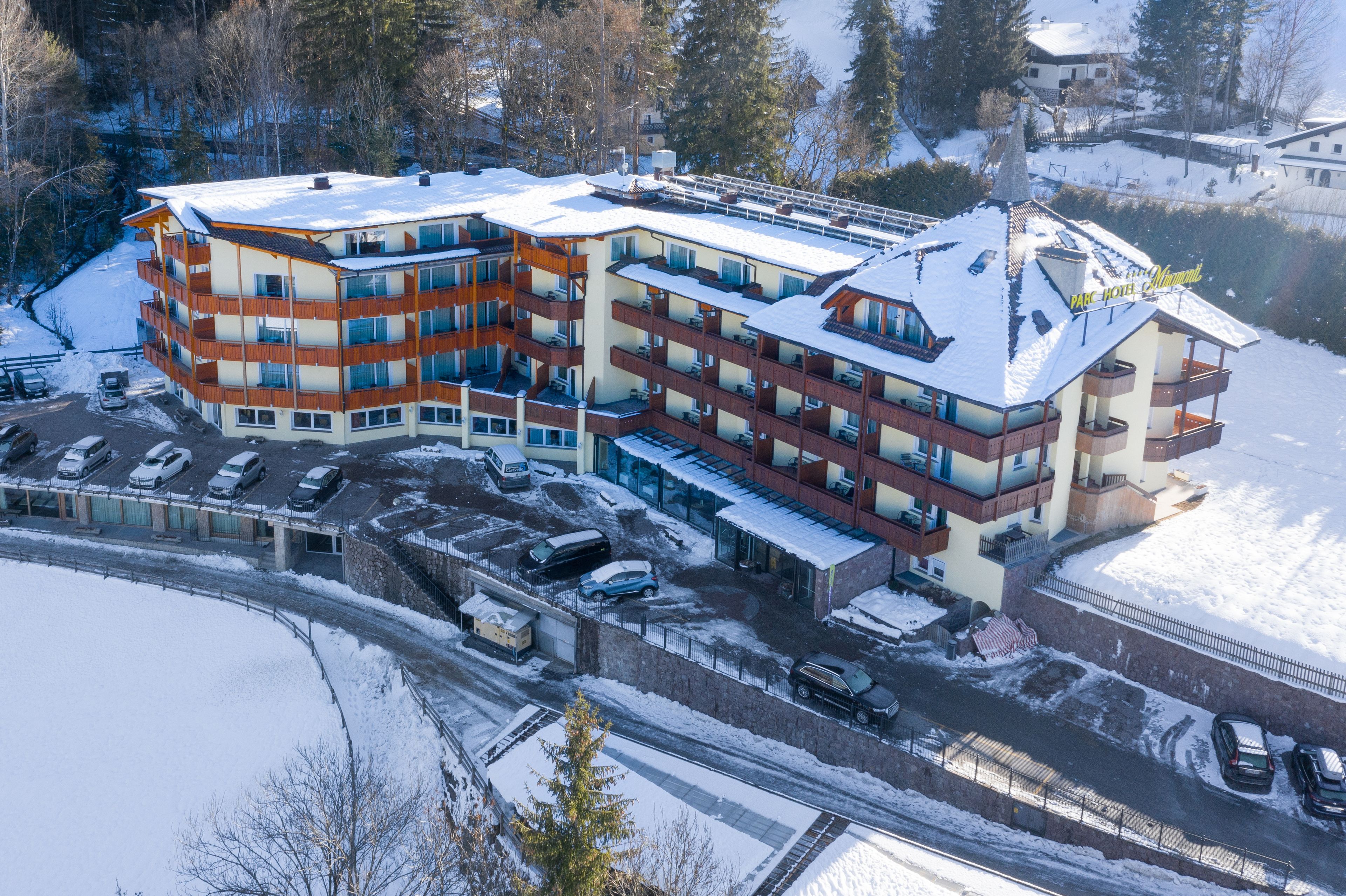 Un hotel de varios pisos con tejado nevado y varias terrazas.