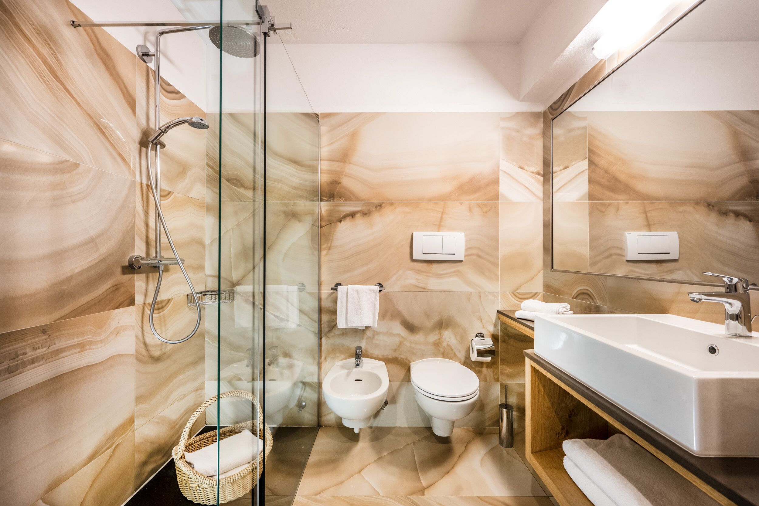 A modern bathroom with a glass-enclosed shower, a freestanding bathtub, and a toilet.