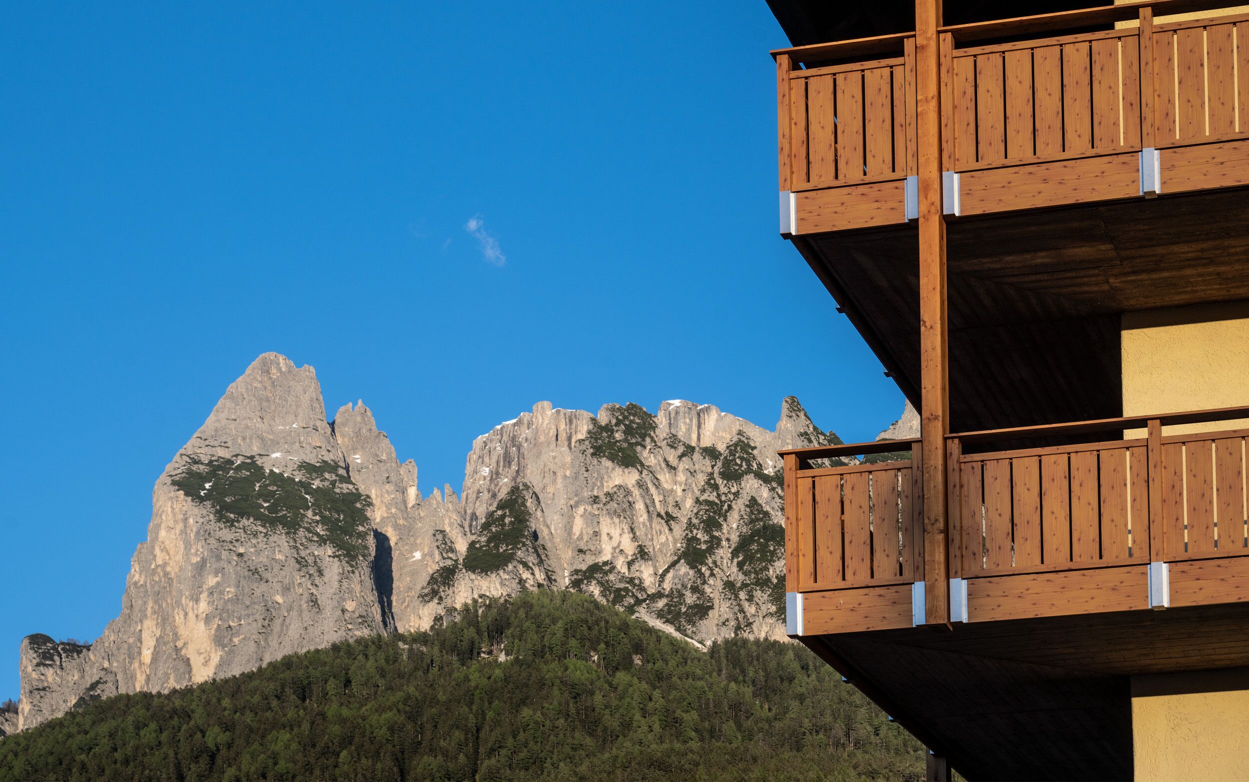 A wooden balcony with a mountain view.