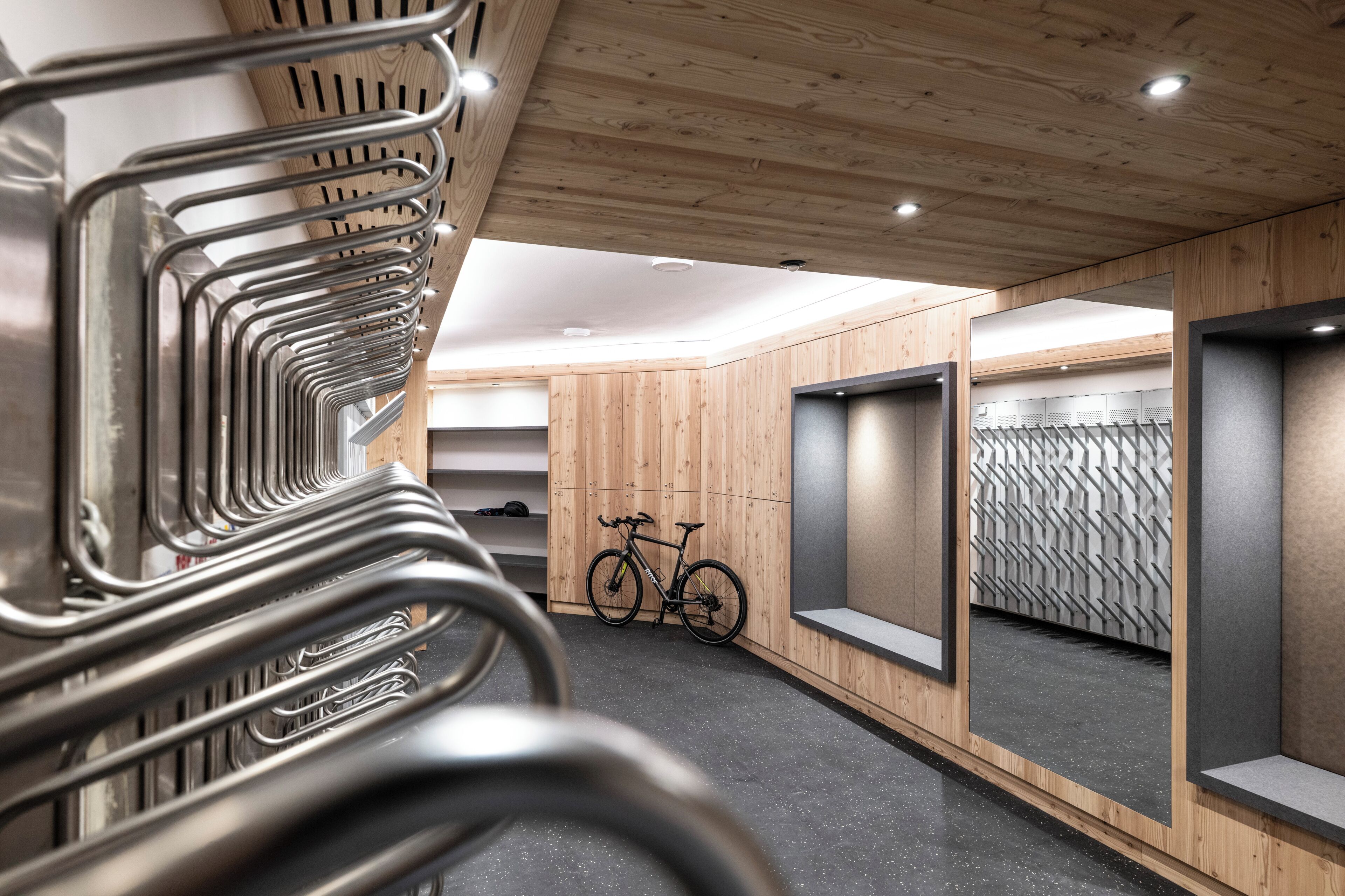 Un interior moderno con techo de madera, una bicicleta y un muro espejado.