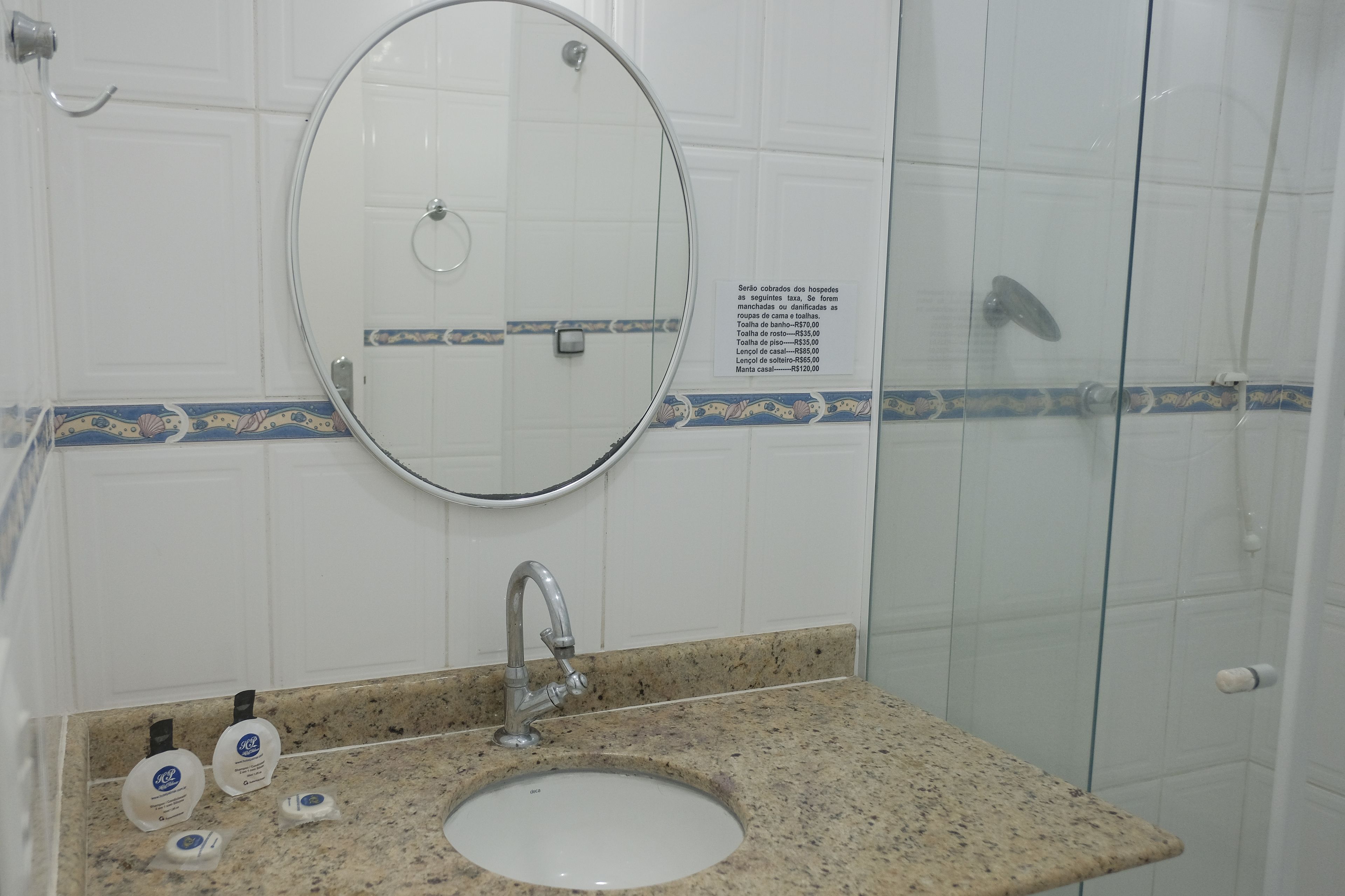 A bathroom with a sink, mirror, and glass shower enclosure.