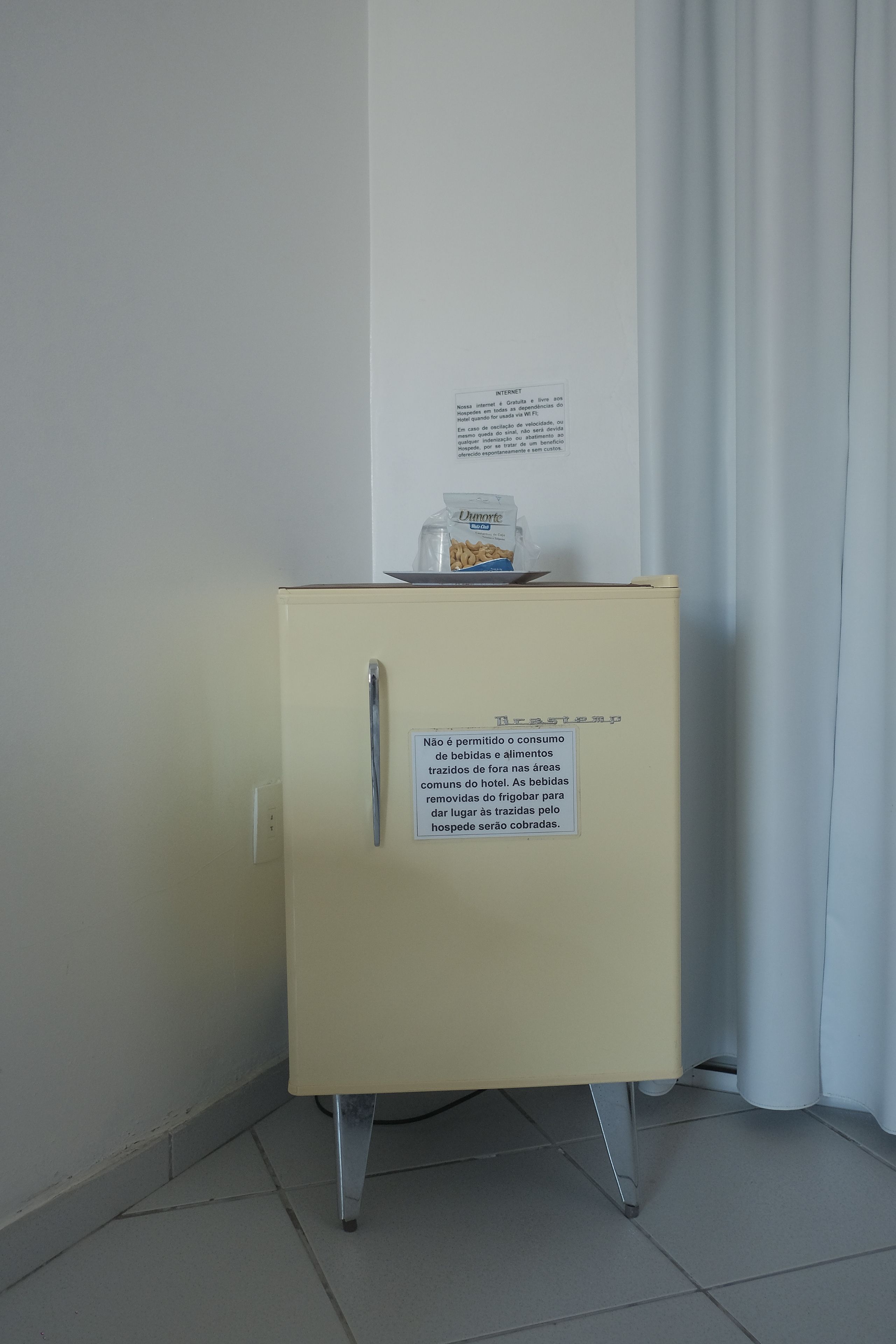 Ein kleiner, gelber Schrank mit einem Schild, das den Verzehr von außerhalb mitgebrachten Speisen und Getränken untersagt.